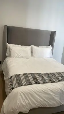 a bed with a gray headboard and white pillows at Ellipse Waterfall 41110 in Midrand
