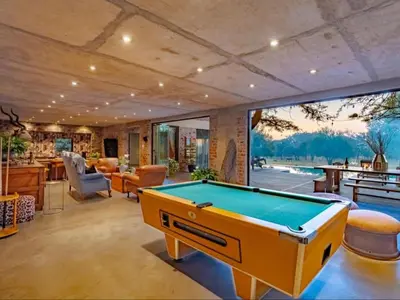 a living room with a pool table in it at Dombeya Private Game Reserve in Vaalwater