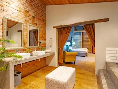 a bathroom with two sinks and a bedroom at Dombeya Private Game Reserve in Vaalwater