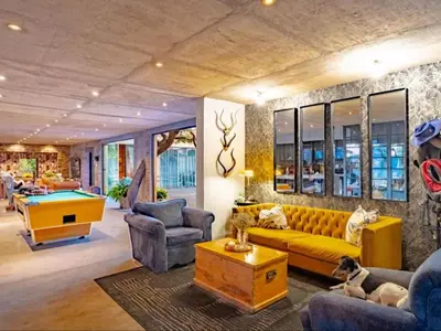 a living room with a yellow couch and a pool table at Dombeya Private Game Reserve in Vaalwater