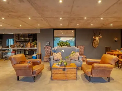 a living room with two chairs and a table at Dombeya Private Game Reserve in Vaalwater