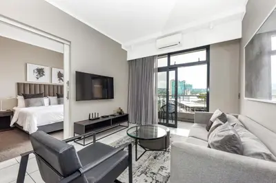 a large living room with a bed and a tv at Menlyn Main Apartments Trilogy Collection in Pretoria