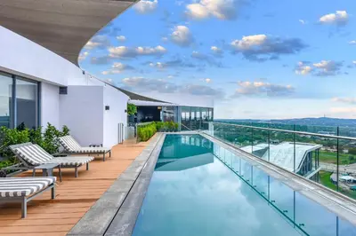 a swimming pool on the roof of a building at Menlyn Main Apartments Trilogy Collection in Pretoria