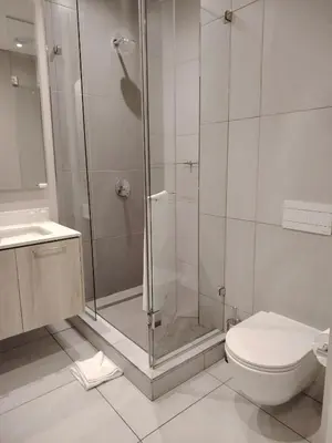 a bathroom with a shower and a toilet and a sink at Menlyn Maine Trilogy Apartment 1506 in Pretoria