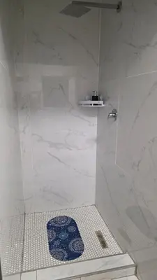 a bathroom with a shower with a blue and white tiles at The village Executive Luxe Suites in Thohoyandou