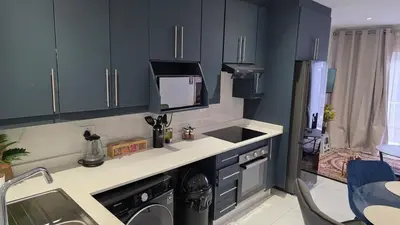 a kitchen with dark blue cabinets and a sink at The village Executive Luxe Suites in Thohoyandou