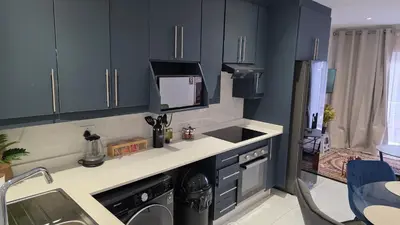 a kitchen with blue cabinets and a sink and a dishwasher at The village Executive Luxe Suites in Thohoyandou