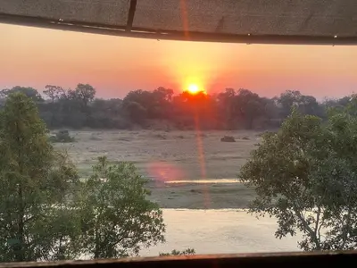 a view of the sunset from a window at Villa Leopards Lookout in Marloth Park