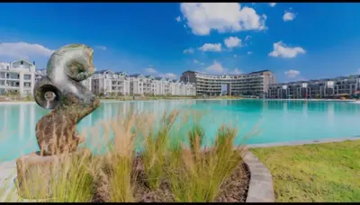 a statue in front of a pool of water with buildings at Munyaka Luxe 4 mins away from Mall of Africa in Midrand