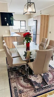 a dining room with a glass table and chairs at Munyaka Luxe 4 mins away from Mall of Africa in Midrand