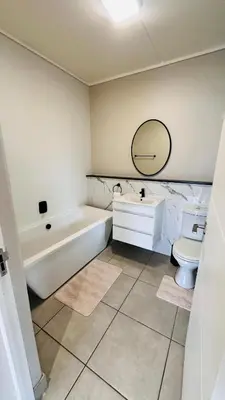 a bathroom with a tub and a toilet and a sink at Munyaka Luxe 4 mins away from Mall of Africa in Midrand