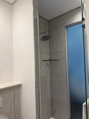 a shower with a glass door in a bathroom at Menlyn Maine Trilogy Apartments When Home is Far in Pretoria