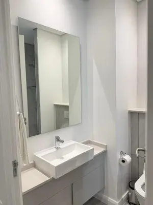 a white bathroom with a sink and a mirror at Menlyn Maine Trilogy Apartments When Home is Far in Pretoria