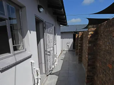 an alley with a fence and a building at Soliha Guesthouse in Trichardt