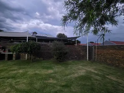 a brick wall with a tent in a yard at Soliha Guesthouse in Trichardt