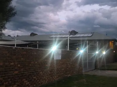 a house with lights on top of a brick wall at Soliha Guesthouse in Trichardt