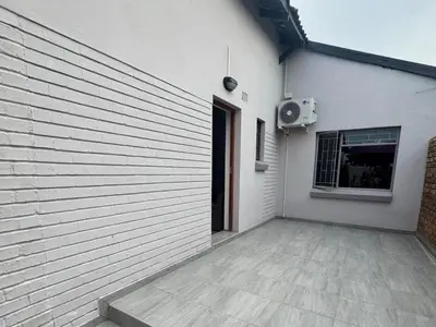 a white building with a door and a window at Soliha Guesthouse in Trichardt