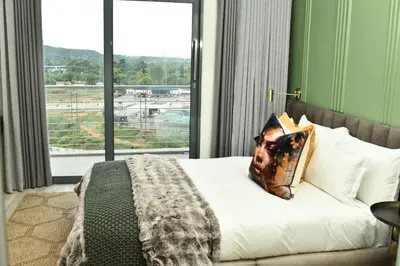 a bedroom with a bed and a large window at Apartment in Menlyn Maine, The Capital Trilogy in Pretoria