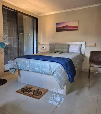 a bedroom with a large bed and a shower at Nare Guesthouse in Soshanguve