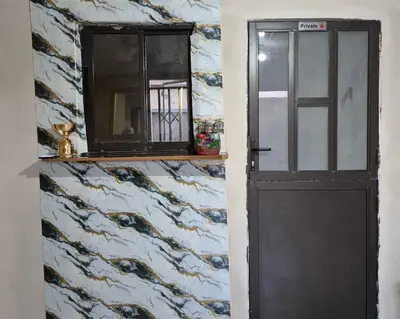 a door with a window and a mirror on a wall at Nare Guesthouse in Soshanguve