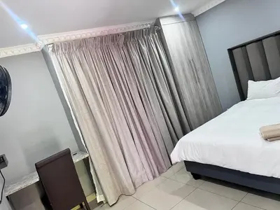 a bedroom with a bed and a window with curtains at MoyMoy Lifestyle Lodge in Meetse-a-Bophelo