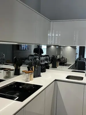 a kitchen with white cabinets and black appliances at Elegant Ellipse Waterfall Luxury with Gym, Spa & Dining in Midrand