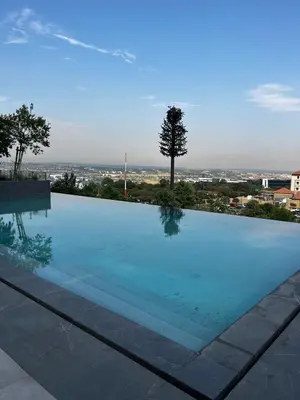 a swimming pool with a view of a city at Elegant Ellipse Waterfall Luxury with Gym, Spa & Dining in Midrand