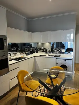 a kitchen with yellow chairs and a glass table at Elegant Ellipse Waterfall Luxury with Gym, Spa & Dining in Midrand