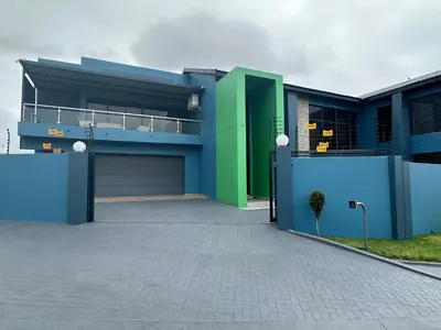 a blue and green house with a garage at Kbros Guesthouse in Polokwane