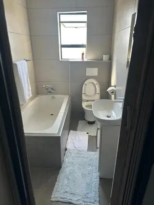 a bathroom with a tub and a toilet and a sink at Kbros Guesthouse in Polokwane