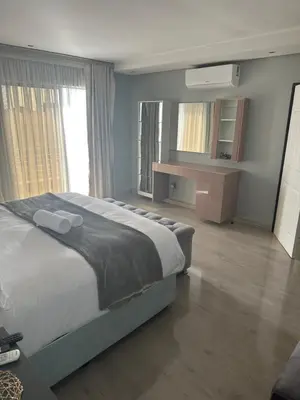 a bedroom with a large bed and a large window at Kbros Guesthouse in Polokwane