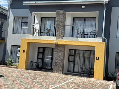 a building with chairs and tables on a balcony at KLAAK hotel and Apartments