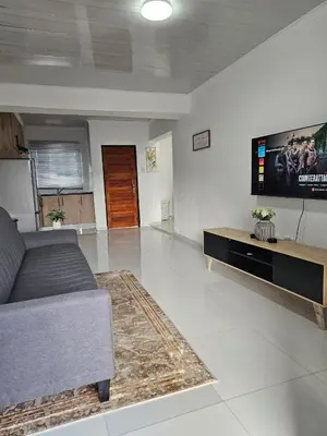 a living room with a couch and a flat screen tv at KLAAK hotel and Apartments