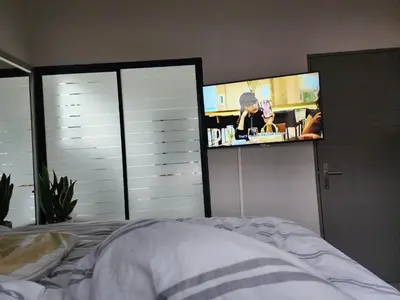 a bedroom with a bed and a flat screen tv at Cozy Corner in Midrand