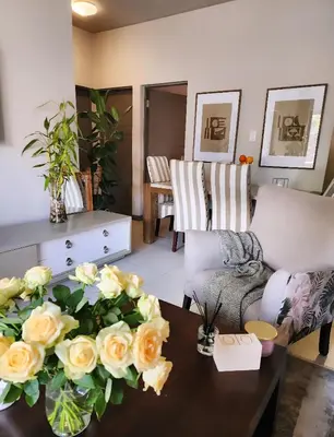 a living room with a table with roses on it at Cozy Corner in Midrand
