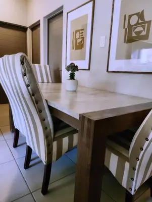 a dining room table with two chairs and a wooden table at Cozy Corner in Midrand