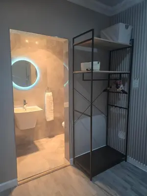 a bathroom with a sink and a shower with a mirror at Cozy Cove Midrand in Midrand