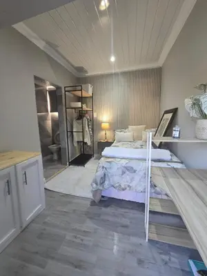 a large bedroom with a bed and a mirror at Cozy Cove Midrand in Midrand