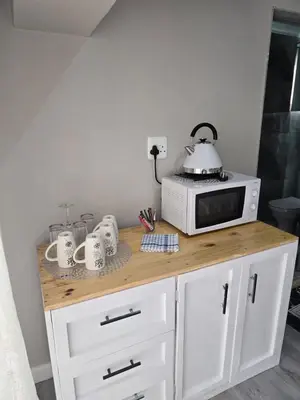 a kitchen counter with a microwave and mugs on it at Cozy Cove Midrand in Midrand