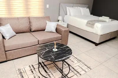 a living room with a couch and a bed at Grace View Guest House in Chartwell