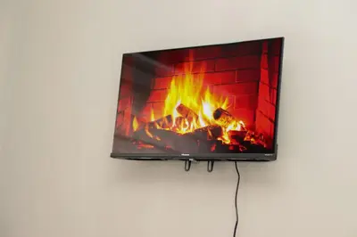 a tv hanging on a wall with a fireplace at Grace View Guest House in Chartwell