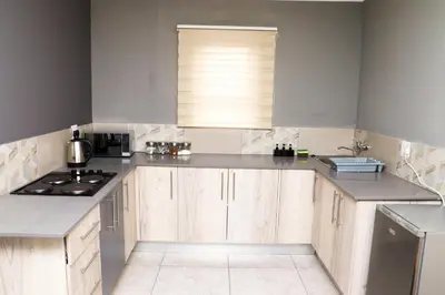 a kitchen with wooden cabinets and a stove top oven at Grace View Guest House in Chartwell