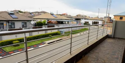 a row of metal railings on a balcony with houses at Grace View Guest House in Chartwell