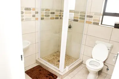 a bathroom with a shower with a toilet and a sink at Grace View Guest House in Chartwell
