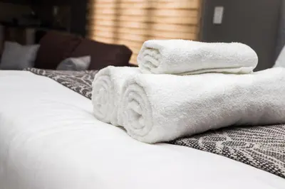a pile of towels sitting on top of a bed at Grace View Guest House in Chartwell