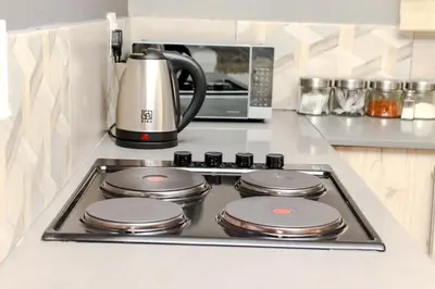 a stove top in a kitchen with a microwave at Grace View Guest House in Chartwell