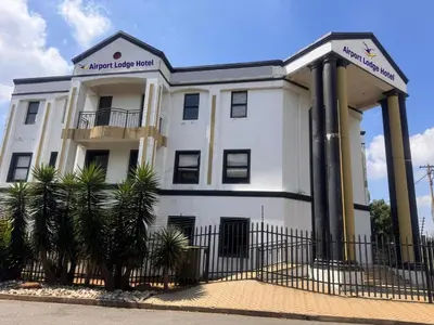 a white building with a sign on it at Airport Lodge Hotel in Kempton Park