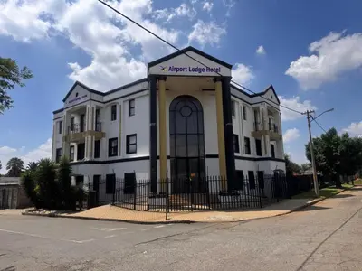 an apartment building on the corner of a street at Airport Lodge Hotel in Kempton Park