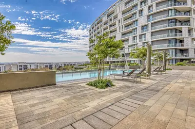 a large apartment building with a pool in front of it at Nova Luxe Midrand Waterfall Ellipse Galileo in Midrand