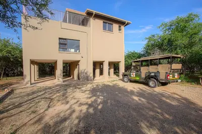 a green jeep parked in front of a house at Penthouse At Kruger Safari Lodge in Marloth Park